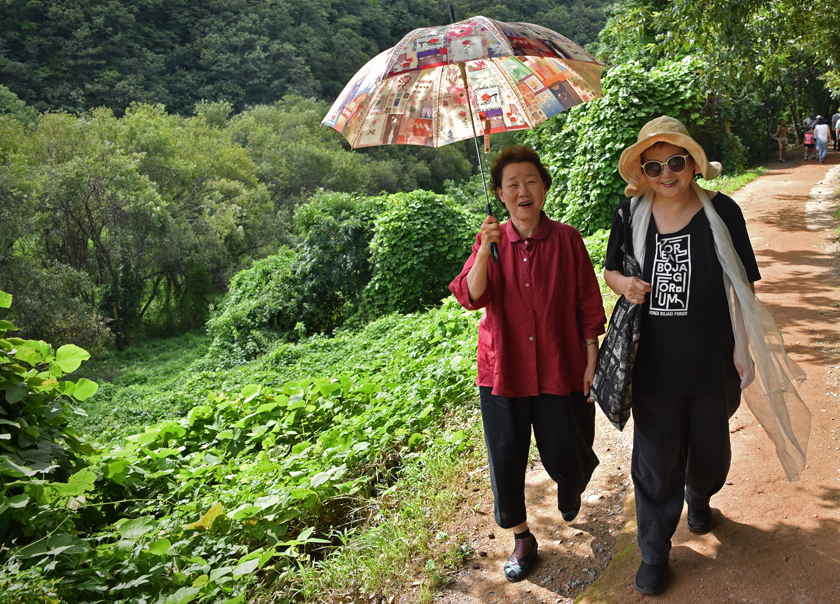 Bojagi artists Insook Choi and Chunghie Lee walking to see the petroglyphs in Bangudae near Ulsan, South Korea.