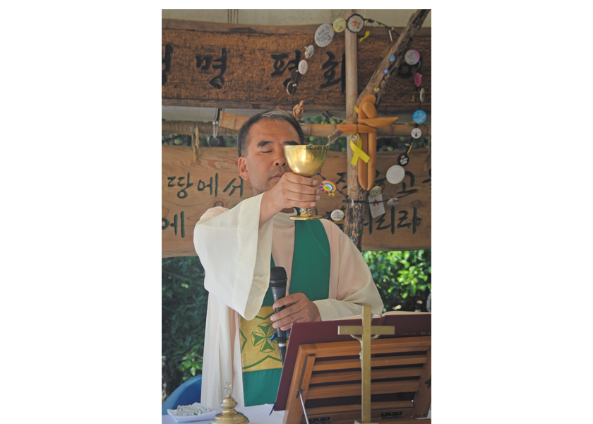 Father Sunghwan Kim celebrates Mass in a makeshift outdoor chapel near the naval base in Gangjeong, Jeju island, South Korea