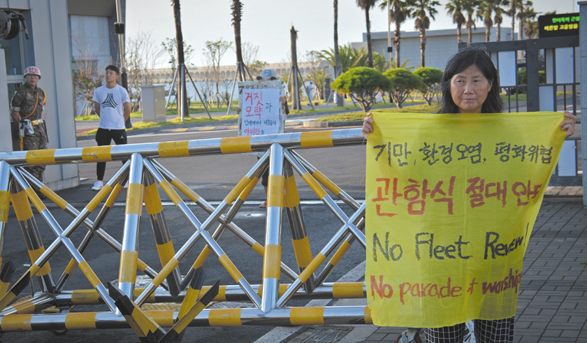 Sunhee Choi protests in front of the main gate to the naval base at Gangjeong, Jeju island, South Korea