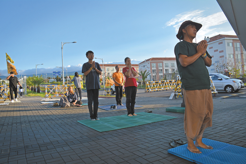 Protesters begin the 100 Bows at the entrance to the naval base, Gangjeong, Jeju island, South Korea