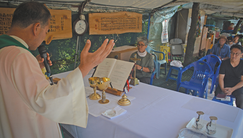 Father Sunghwan Kim celebrates Mass in a makeshift outdoor chapel near the naval base in Gangjeong, Jeju island, South Korea