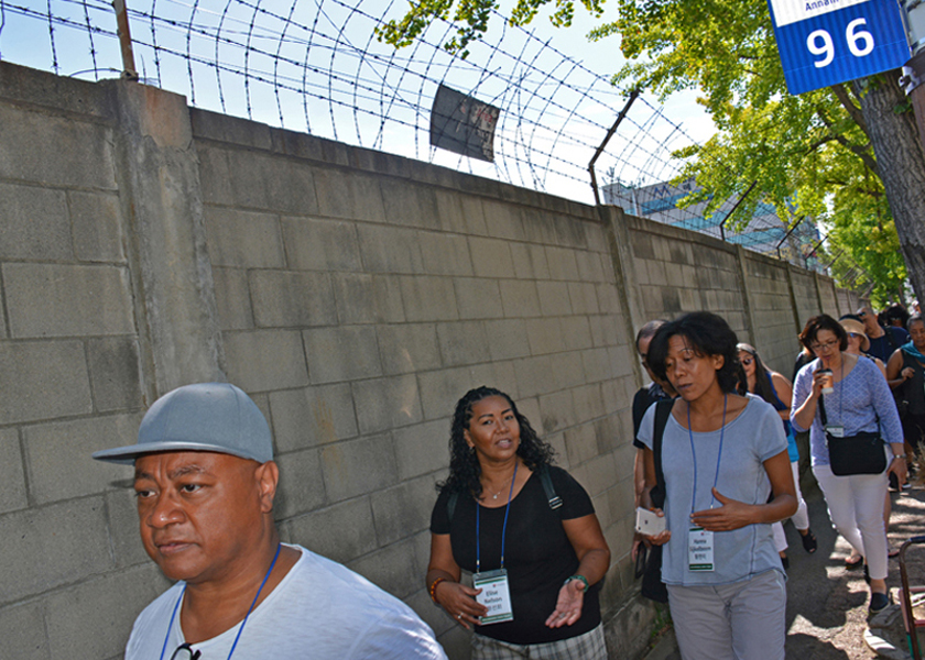 Adopted Korean Mosiac Hapa tour: Chang Lee Nielsen, Elise Nelson and Hanna Eijkelboom walk along the wall of the old military base in the  Shinchon neighborhood in Bupyeong, east of Seoul, South Korea