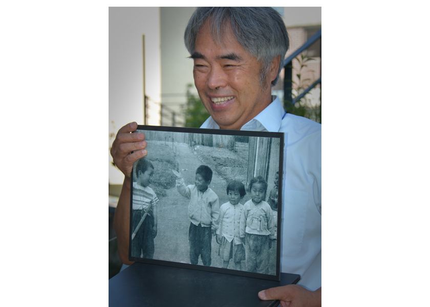 Adopted Korean Mosiac Hapa tour: Shinchon historian Myong-sik Kim with photo of hapa kids in Shinchon in the 1960s