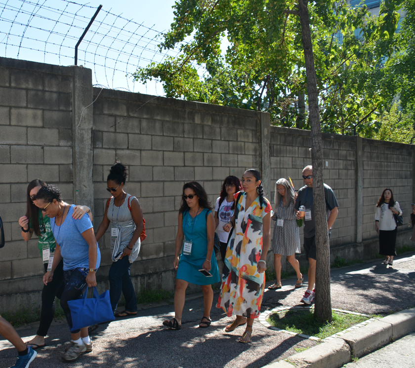 Adopted Korean Mosiac Hapa tour members walk along a wall that surrounds the decommissioned military base in the Shinchon neighborhood, South Korea.