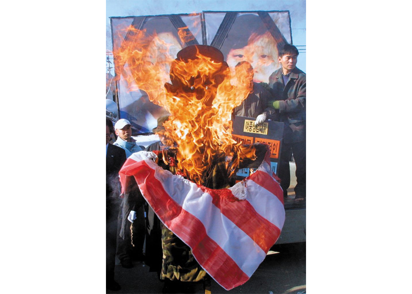 Protesters burn an effigy of U.S. President George W. Bush in response to the 2002 incident in which an American military vehicle crushed two 14-year-old girls to death.